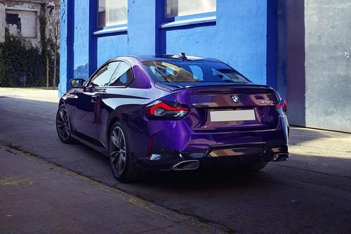 BMW 2 Series Purple Coupe rear left side angle view showing taillights, tailgate and alloy wheels BMW 2 Series Purple Coupe rear left side angle view showing taillights, tailgate and alloy wheels