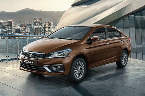 Suzuki Ciaz 2026 Brown Sedan Front Right Side Angle View on City Street Suzuki Ciaz 2026 Brown Sedan Front Right Side Angle View on City Street