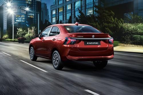 Suzuki Dzire 2026 Red Sedan Rear Left Side Angle View Showing Taillights, Tailgate and Alloy Wheels Suzuki Dzire 2026 Red Sedan Rear Left Side Angle View Showing Taillights, Tailgate and Alloy Wheels